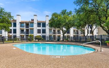a swimming pool with an apartment building in the background